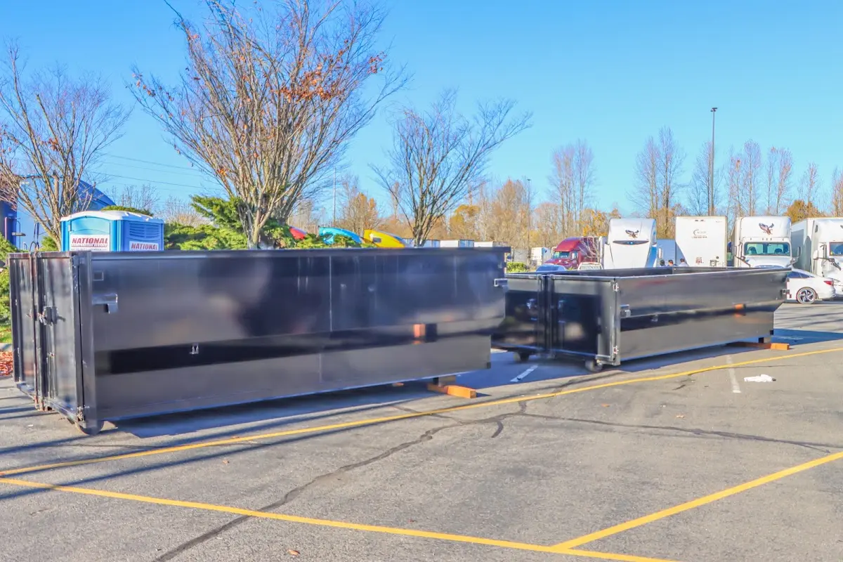 Professional dumpster rental service with roll-off container on residential driveway in Sayre